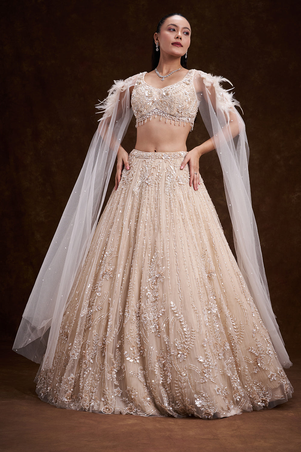 Cream Net Bridal Lehenga with Feathered Shoulder Detail and Embellished Cape
