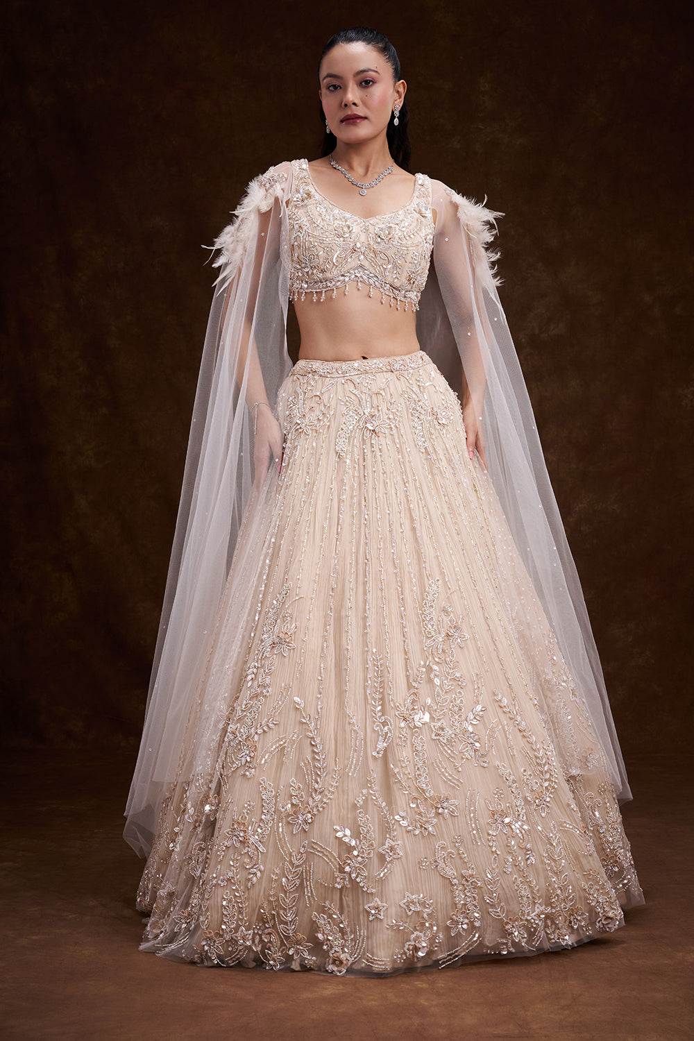 Cream Net Bridal Lehenga with Feathered Shoulder Detail and Embellished Cape