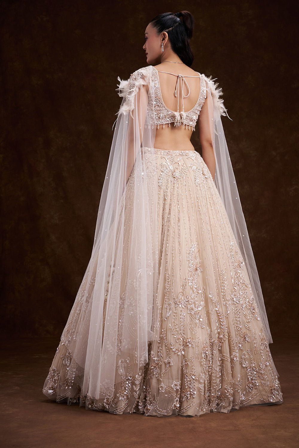 Cream Net Bridal Lehenga with Feathered Shoulder Detail and Embellished Cape