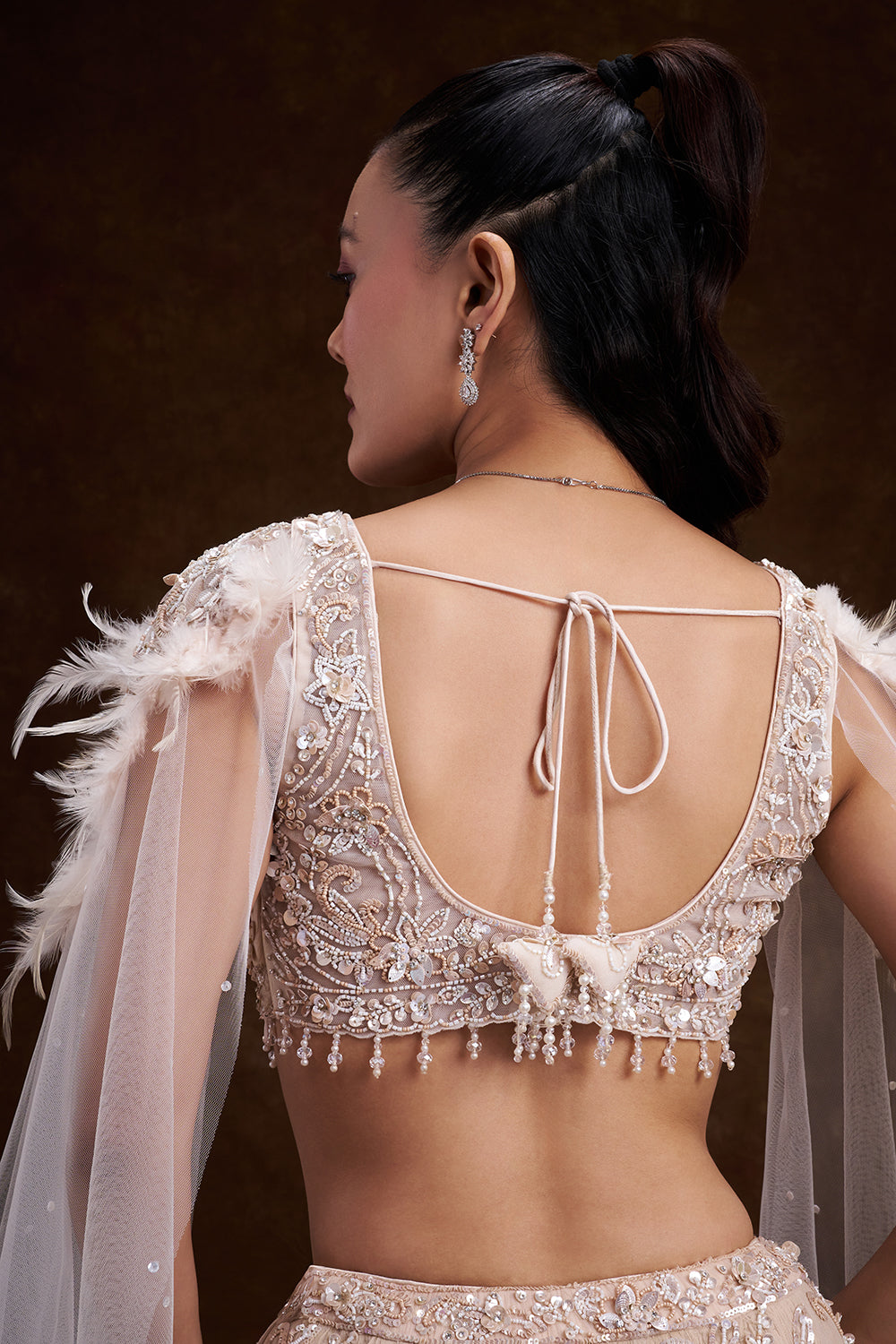 Cream Net Bridal Lehenga with Feathered Shoulder Detail and Embellished Cape