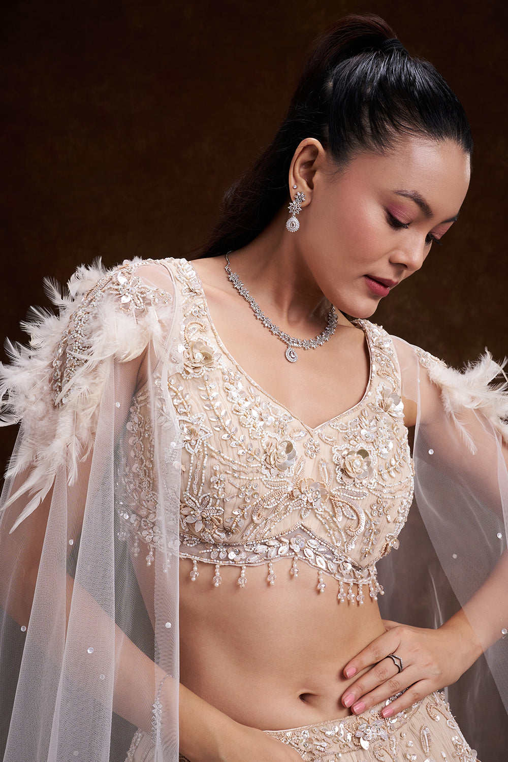 Cream Net Bridal Lehenga with Feathered Shoulder Detail and Embellished Cape